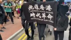 Հոնկոնգի ցուցարարները քայլում են "Ազատագրել Հոնկոնգը՝ մեր ժամանակների հեղափոխությունը" գրությամբ դրոշը ձեռքերին
