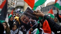 Lebanese and Palestinians students burn a poster of U.S. President Donald Trump as they take part in a protest, in the southern port city of Sidon, Lebanon, Dec. 7, 2017. 