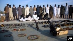 FILE - Arrested suspects and recovered weapons are displayed for the media by Pakistani paramilitary forces following a search operation in Shah Kass, an area of Pakistan's Khyber tribal region along the country's border with Afghanistan, March 3, 2017.