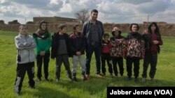 Yazidi children, recently freed from the Islamic State group, are pictured with their aid worker, near Hasaka, Syria, Feb. 27, 2019. (J. Jendo/VOA) 