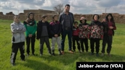 Some Yazidi children, who were recently freed from Islamic State, pose for a picture with their aid worker, near Hasaka, Syria, Feb. 27, 2019. (Jabber Jendo/VOA) 