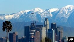 File - In this Jan. 12, 2016 file photo, the snow-capped San Gabriel Mountains stand as a backdrop to the downtown Los Angeles skyline. An initiative that seeks to split California into three states is projected to qualify for the state's November 2018 ballot.