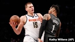 Nikola Jokić u prodoru pored beka Bruklin Netsa Dianđela Rasela (Foto: AP/Kathy Willens) 