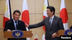 26일 일본 도쿄 총리관저에서 진행된 정상회담 직후 합동기자회견에서 웃고 있는 로드리고 두테르테(왼쪽) 필리핀 대통령과 아베 신조 총리.