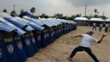 A mock protester throws a water bomb during police exercises to manage civil unrest in Manila, Philippines ahead of a visit by US President Barack Obama.