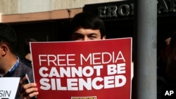 Un manifestant tient une pancarte lors d'un rassemblement en faveur de la liberté de la presse près du siège d'une société de médias à Istanbul, mercredi 28 octobre 2015. (AP Photo/Lefteris Pitarakis)