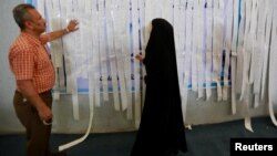 Employees of the Iraqi Independent High Electoral Commission inspect the results of a ballot box printout at a warehouse in Najaf, Iraq, May 15, 2018.