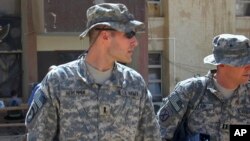 FILE - 1st Lt. Michael C. Behenna, left, and his defense attorney Capt. Tom Clark, right, walk in Camp Speicher, a large U.S. base near Tikrit, north of Baghdad, Iraq, Sept. 21, 2008.