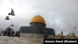 Orang-orang berjalan di dekat Masjid Al-Aqsa di kompleks yang dikenal oleh orang Yahudi sebagai Temple Mount dan Muslim sebagai Kota Suci, di Kota Tua Yerusalem, 14 Maret 2019. (Foto: REUTERS/Ammar Awad)