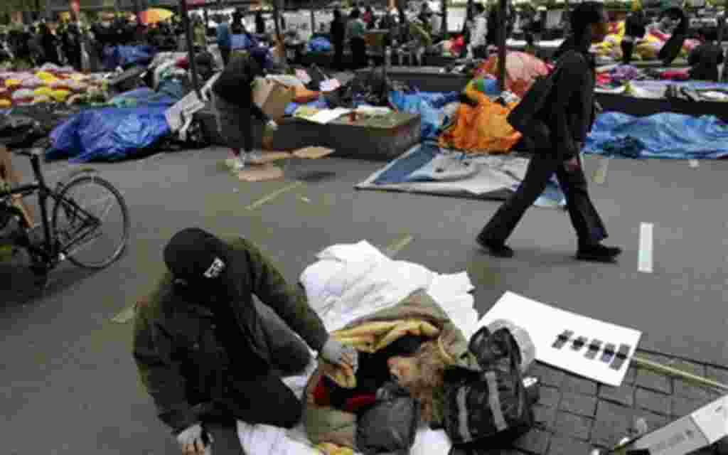 Una mujer habla con un amigo después de dormir en Zuccotti Park, en el distrito financiero de Nueva York.