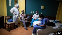 Médicos venezolanos se relajan tras una jornada de trabajo asistiendo a pacientes asintomáticos con COVID-19 en cuarentena, en un hotel en Caracas, Venezuela. Agosto 29, 2020. 