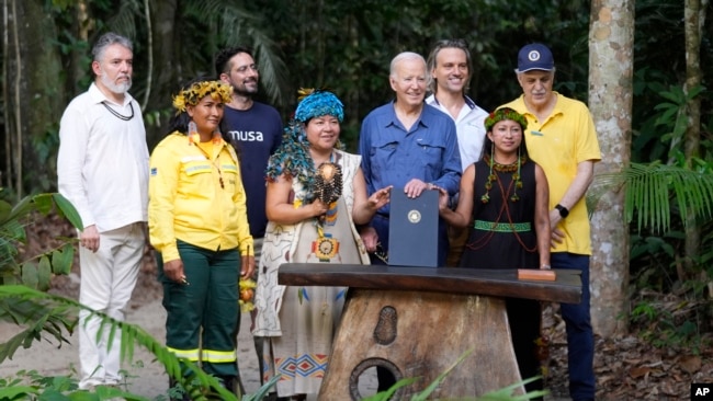 El presidente de EEUU, Joe Biden, posa con activistas después de firmar una proclamación del Día Internacional de la Conservación, el 17 de noviembre en Manaus, Brasil.