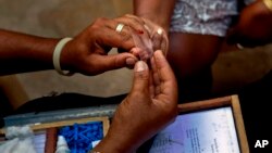 A health service worker takes a blood sample for a malaria test in Dajabon, Dominican Republic, on the border with Haiti, Oct. 6, 2009. A test that doesn't require a needle or blood has won the Africa Prize for Engineering Innovation.