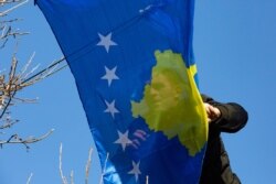 A municipality worker hangs Kosovo's flag to decorate the main street, during the 12th anniversary of the country's independence in the capital Pristina, Feb. 17, 2020. Kosovo declared independence from Serbia in 2008.