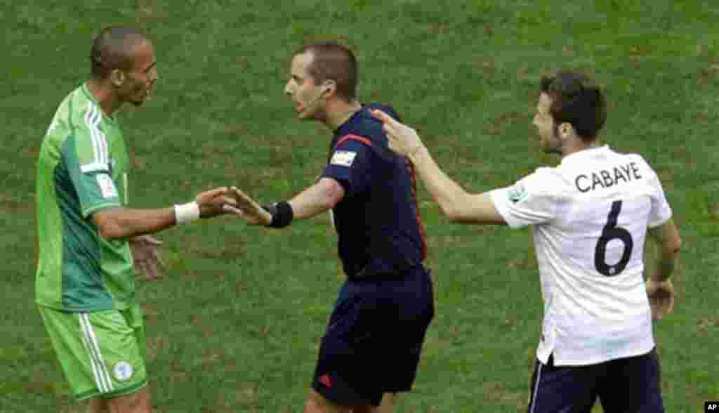 Referee Mark Geiger from the United States, center, tries to arbitrate an argument by Nigeria's Peter Odemwingie, left, and France's Yohan Cabaye during the World Cup round of 16 soccer match between France and Nigeria at the Estadio Nacional in Brasilia,