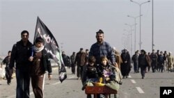 Shiite pilgrims march on their way to Karbala for Arbaeen, in Baghdad, Iraq, Thursday, Jan. 20, 2011. The holiday marks the end of the forty-day mourning period after the anniversary of the 7th century martyrdom of Imam Hussein, the Prophet Muhammad's gra