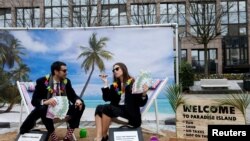 Activists stage a protest on a mock tropical island beach representing a tax haven outside a meeting of European Union finance ministers in Brussels, Belgium, Dec. 5, 2017. 