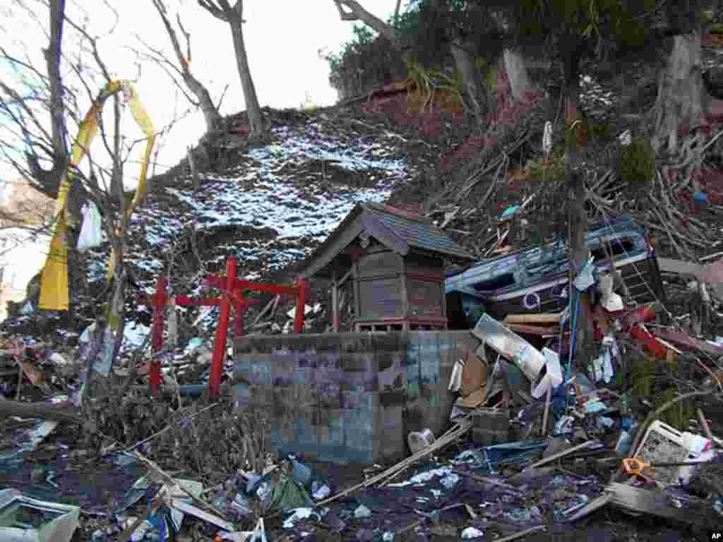 A wrecked car rests above a Shinto shrine in Kamaishi, Japan, March 17, 2011 (H. Ridgwell)