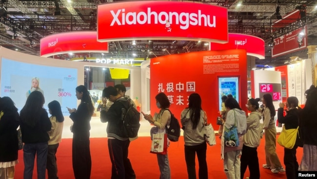 FILE - Visitors line up near the booth for Xiaohongshu app at the China International Import Expo in Shanghai, China, Nov. 6, 2024.