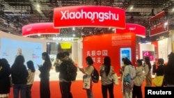 ARCHIVO - Los visitantes hacen fila cerca del stand de la aplicación Xiaohongshu en la Exposición Internacional de Importaciones de China en Shanghai, China, el 6 de noviembre de 2024.