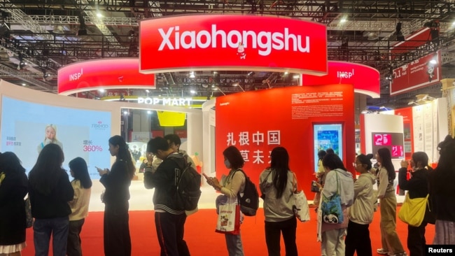 ARCHIVO - Los visitantes hacen fila cerca del stand de la aplicación Xiaohongshu en la Exposición Internacional de Importaciones de China en Shanghai, China, el 6 de noviembre de 2024.