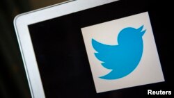 FILE - A portrait of the Twitter logo. A British man has been charged with using social media to incite racial hatred after posting anti-Muslim tweets in the days after the Brussels attacks.