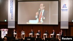 Menteri Keuangan AS Steven Mnuchin (kanan) di podium menyampaikan pidato dalam simposium mengenai perpajakan internasional dalam pertemuan Menteri Keuangan dan Gubernur Bank Sentral G20 di Fukuoka, Jepang, 8 Juni 2019.
