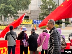 在国家档案馆外，法轮功抗议人士与欢迎习近平来访的人士隔街相对。(2026年9月25日)