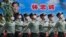 列队经过中国国家主席习近平海报前的解放军官兵