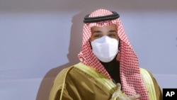FILE - Saudi Crown Prince Mohammed bin Salman wears a face mask to help curb the spread of the coronavirus as he attends the Saudi Cup, at King Abdul Aziz race track in Riyadh, Saudi Arabia, Feb. 20, 2021.