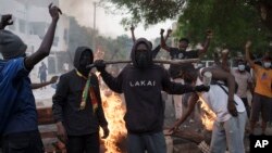 Demonstrators stand next to a barricade set on fire during a protest in support of the main opposition leader Ousmane Sonko in Dakar, Senegal, May 29, 2023.