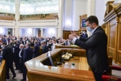 Ukrainian President Volodymyr Zelenskiy, wearing a protective mask used as a preventive measure against coronavirus disease (COVID-19), gives thumbs-up during a session of parliament in Kyiv, Ukraine, March 31, 2020.