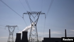 Electricity pylons are seen near Arnot Power Station's cooling towers, east of Middelburg in Mpumalanga province, South Africa, Sept. 8, 2015.