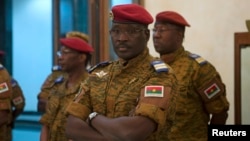 FILE - Burkina Faso Prime Minister Yacouba Isaac Zida listens as an official reads the names of transitional government ministers, in Ouagadougou, Burkina Faso.