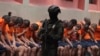 Un soldado vigila a los reclusos en la Penitenciaría del Litoral durante una gira de prensa organizada por el ejército, en Guayaquil, Ecuador, el viernes 9 de febrero de 2024. 