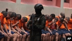 Un soldado vigila a los reclusos en la Penitenciaría del Litoral durante una gira de prensa organizada por el ejército, en Guayaquil, Ecuador, el viernes 9 de febrero de 2024. 