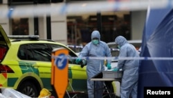 Los oficiales forenses trabajan en la escena de un apuñalamiento en el Puente de Londres, en el que murieron dos personas, en Londres, Gran Bretaña.