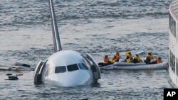 Sully Movie Investigators: FILE - In this Jan. 15, 2009 file photo, passengers in an inflatable raft move away from an Airbus 320 US Airways aircraft that has gone down in the Hudson River in New York. Accident investigators say they object to their portrayal in a new movie based on the “Miracle on the Hudson” river ditching of airliner seven years ago after striking geese. 