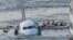 Sully Movie Investigators: FILE - In this Jan. 15, 2009 file photo, passengers in an inflatable raft move away from an Airbus 320 US Airways aircraft that has gone down in the Hudson River in New York. Accident investigators say they object to their portrayal in a new movie based on the “Miracle on the Hudson” river ditching of airliner seven years ago after striking geese. 