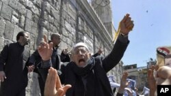 A Syrian pro-government protester shouts slogans during a protest following Friday prayers outside the Omayyad Mosque in Damascus, Syria, April 15, 2011