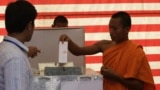 Cambodian Buddhist monk, right, casts his ballot in local elections at Wat Than pagoda's polling station in Phnom Penh, Cambodia, Sunday, June 3, 2012.