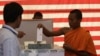 Cambodian Buddhist monk, right, casts his ballot in local elections at Wat Than pagoda's polling station in Phnom Penh, Cambodia, Sunday, June 3, 2012. Prime Minister Hun Sen's ruling party was expected to win the elections in a vote that monitors say is tainted by vote buying and other irregularities. (AP Photo/Heng Sinith)