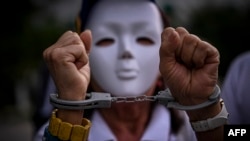 A woman wearing handcuffs attends a rally in Panama City to protest the disputed July 28 presidential election in Venezuela. Sept. 28, 2024. The rally was one of several held outside Venezuela to show support for Venezuela's opposition, which says its candidate won the race.