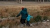 Un migrante guatemalteco y su hijo cruzan la frontera natural de Río Grande entre El Paso, estado de Texas, Estados Unidos, y Ciudad Juárez, estado de Chihuahua, México, en busca de asilo político el 26 de enero de 2021.