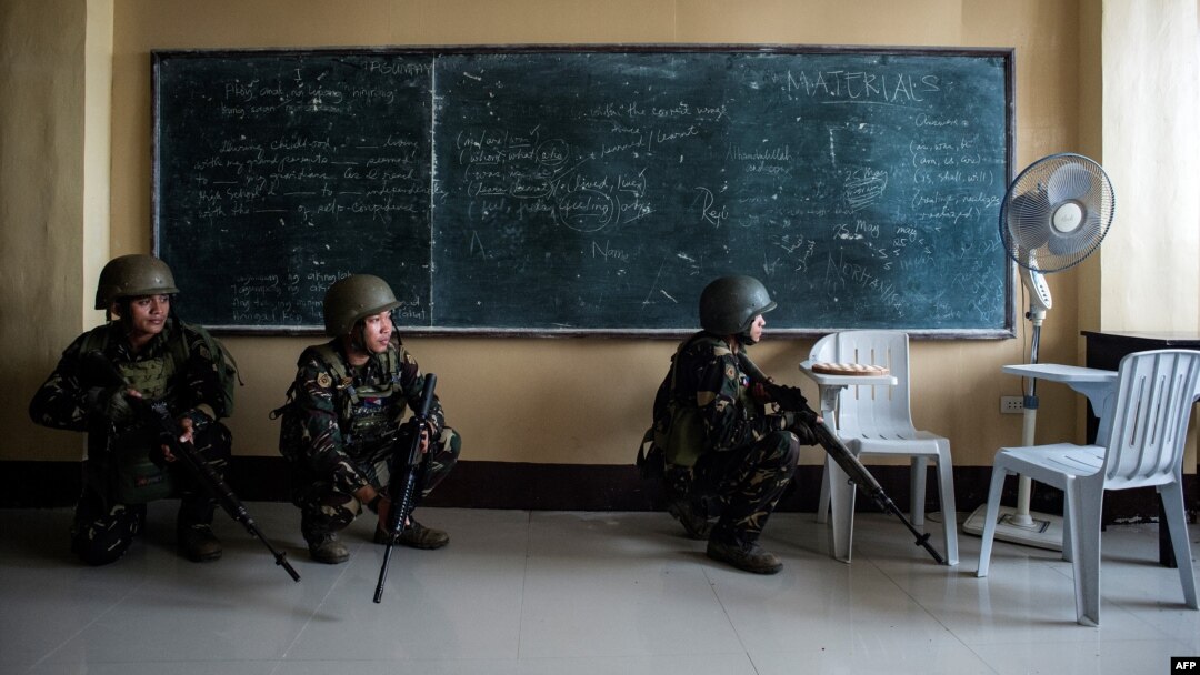 Philippine Army Scout Rangers crouch in a classroom during a mission to flush out Islamist militant snipers in Marawi, on the southern island of Mindanao, June 6, 2017. 