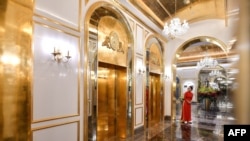 Seorang staf berdiri di dekat lift di lobi hotel Dolce Hanoi Golden Lake yang baru diresmikan, hotel berlapis emas pertama di dunia, di Hanoi, 2 Juli 2020. (Foto: Ilustrasi/AFP)