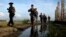 Myanmar police officers patrol along the fence bordering Bangladesh in Maungdaw, Rakhine State, Myanmar, Oct. 14, 2016. New reports accuse soldiers of brutality against Myanmar's long-persecuted Rohingya Muslims.