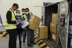 Staff of the World Food Programme (WFP) check boxes that arrived, mostly personal protective equipment (PPE), at Ethiopian Airlines' cargo facility at the Bole International Airport in Addis Ababa, April 14, 2020.