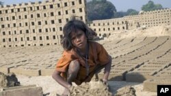 A 9-year-old girl toils under the hot sun, making bricks from morning to night, seven days a week.