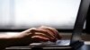 Seorang perempuan sedang mengetik di laptop. Pandemi ternyata membuat praktik menggunakan joki dalam tugas sekolah marak. (Foto: AP)